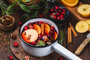 Cranberry non-alcoholic mulled wine in a ladle, with cranberries, cinnamon, apples and citrus fruits with spices