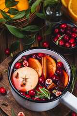 Cranberry non-alcoholic mulled wine in a ladle, with cranberries, cinnamon, apples and citrus fruits with spices