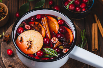 Cranberry non-alcoholic mulled wine in a ladle, with cranberries, cinnamon, apples and citrus...