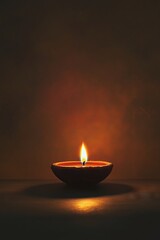A close-up of a clay oil lamp with a glowing flame against a dark background, symbolizing light, peace, and spirituality.