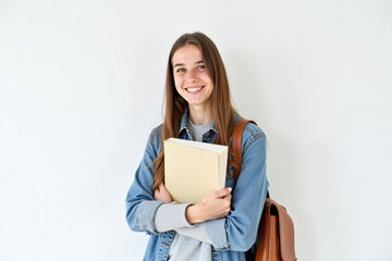 Fototapeta premium Young woman with book and backpack, studious, casual outfit