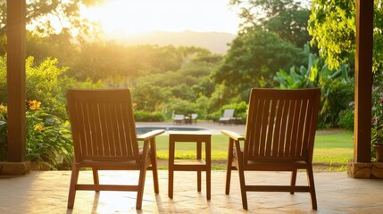 Obraz premium Two wooden chairs and a small table set in a serene outdoor space, bathed in warm sunlight at sunset, inviting relaxation and comfort.