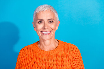 Portrait of positive middle aged woman smiling toothy look wear season sweater isolated blue color background