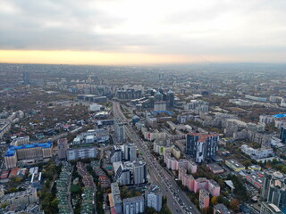 Obraz premium View of the city, with different buildings and streets. Sunset time. Autumn. The view from the drone.