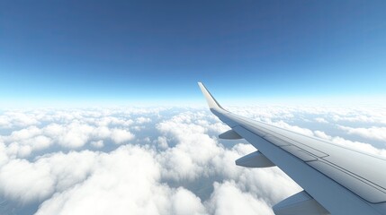 Fototapeta premium Airplane Wing Above White Clouds with Blue Sky