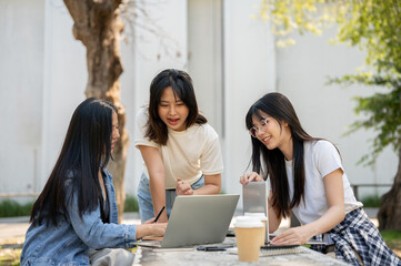 A group of young Asian female college students is focused on discussing a project.