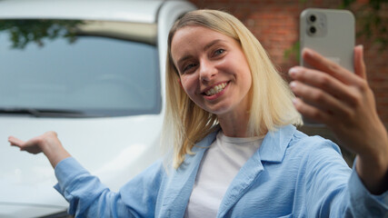 Cheerful Caucasian woman car owner client talking video call happy girl driver speak filming blog...