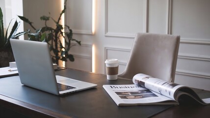 Modern office desk with laptop, coffee, and newspaper