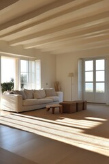 Obraz premium Bright and airy living room featuring a white sofa, natural decor elements, and large windows letting in abundant sunlight.