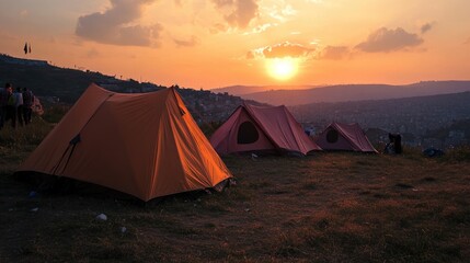 Tents set up on a hillside during sunset