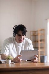 Man Sitting and Relaxing with Tablet and Headphones in Modern Home Environment