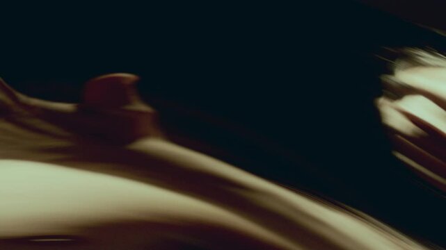 Shirtless long-haired dancer, reflected in distorting mirror, flowing through fluid and enigmatic movements in hypnotic performance