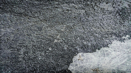 Close-up shot of a grey and white textured surface showing the rough and uneven nature of the material. Classic, elegant and charming textured background photo for banner background.