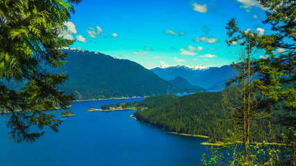 Burrard Inlet, BC,  on a sunny day with alpine mountain peaks on far horizon.