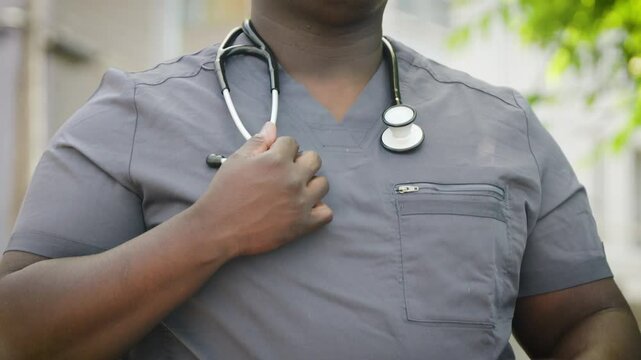 Black Male Hands Putting on a Stethoscope in Scrubs