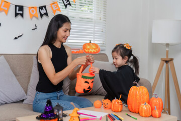 Mother and Daughter Enjoy Halloween Activities Together, Carving Pumpkins and Decorating Their Home with Festive Decorations