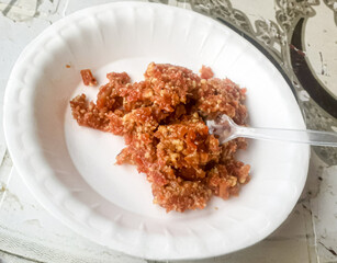 Carrot fresh pudding in white plate with spoon.