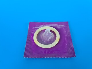 A close-up view of a condom on a blue background highlighting its packaging and design for safe sex...