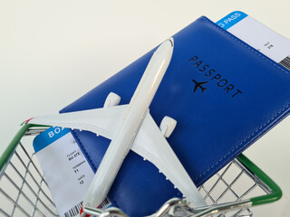 Travel essentials including a passport, boarding passes, and a miniature airplane model in a shopping cart inviting adventurous journeys