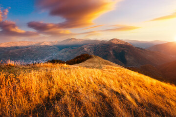 Obraz premium A fantastic sunset in the mountains with distant ridges illuminated by the sun. Carpathian mountains, Ukraine.