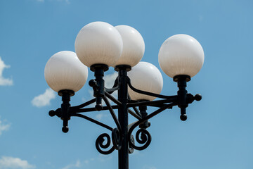 A street light with five white globes on it