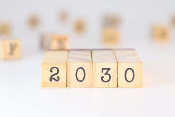 Year 2030 design. Numbers written on wooden cubes isolated on white background with copy space. Climate objective concept.