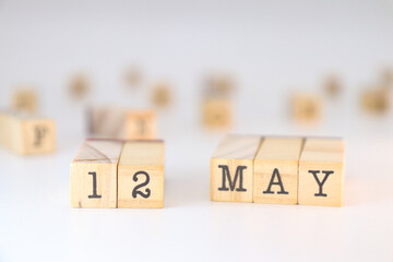 May 12 written on wooden cubes isolated on white background with copy space for text