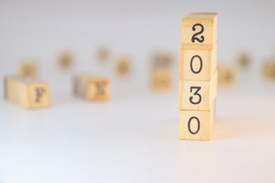 Year 2030 design. Numbers written on wooden cubes isolated on white background with copy space. Climate objective concept.