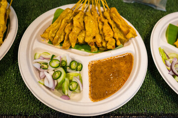 Authentic Thai Pork Satay with Creamy Peanut Sauce, Topped with Shallots and Spicy Fresh Chilies