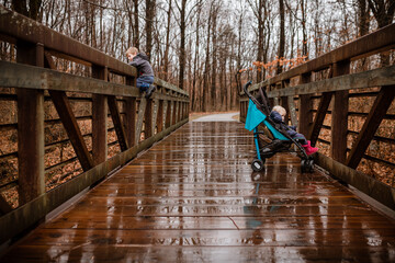 Young kids on daily walk down nature trail on rainy day