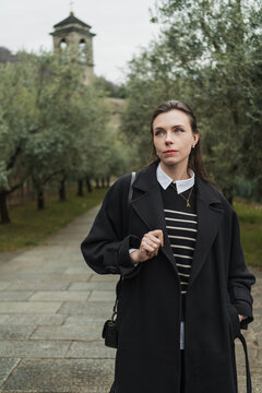 Cropped view of a young adult woman walking away from the bell tower