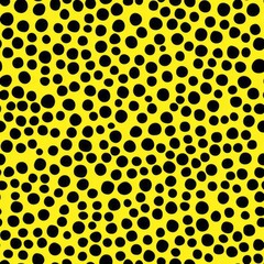seamless pattern of overlapping bold black dots on a bright yellow backdrop