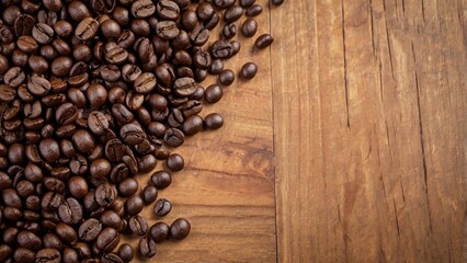 Fototapeta premium A pile of roasted coffee beans on a wooden background with copy space area
