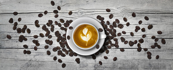 Full coffee cup on white  floor boards  with coffee beans sprinkled around