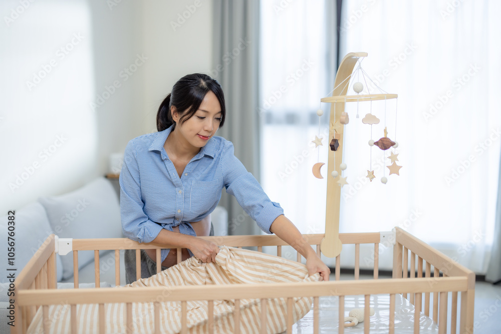 Wall mural Pregnant woman prepare baby bed at home