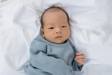 Little baby boy lying on bed