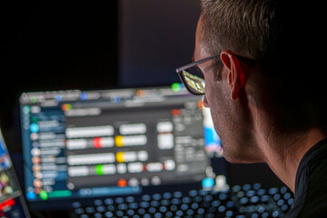 Cybersecurity Professional Analyzing Data on Multiple Screens in a Low-Light Workspace for Network Security Assessment