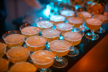 Row of Cocktail Glasses with Frothy Beverages in Warm Light