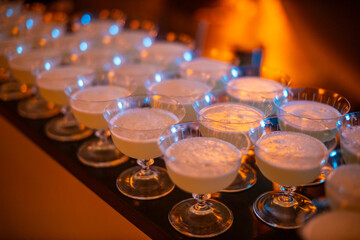 Row of Cocktail Glasses with Frothy Beverages in Warm Light