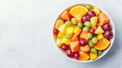 A colorful bowl of fresh fruit including grapes, pineapple, orange, and melon, perfect for a healthy snack or dessert.