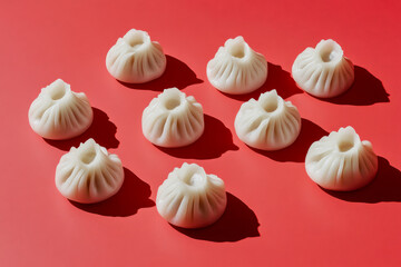 Overhead view of fresh Chinese dumplings on a red background