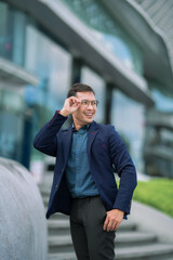 Fototapeta premium person, business, businessman, adult, man, male, happy, lifestyle, portrait, success, confident, professional, handsome, cheerful, corporate, city, young, caucasian, manager, one, smile, suit, backgro