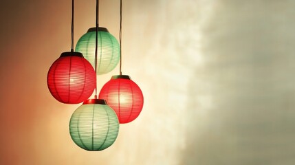 Simple red and green lamps, softly lit, hang in a set against a cream background, exuding a calm, modern aesthetic.