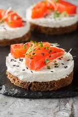 Smoked Salmon cheesecake breakfast sandwich toast closeup on slate plate on table. Vertical
