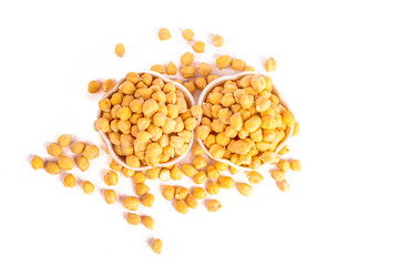 Dried chickpeas in white bowl on white. Spilled chickpeas.