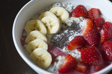 Editorial photo of oatmeal bowl with bananas, strawberries, and chia seeds
