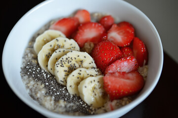 Editorial photo of oatmeal bowl with bananas, strawberries, and chia seeds