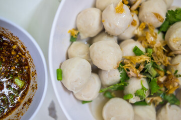 Boiled pork meatballs sprinkle with fried garlic and coriander. Thai food delicious