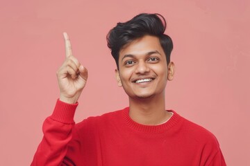 A person wearing a bright red sweater points upwards, possibly indicating excitement or surprise