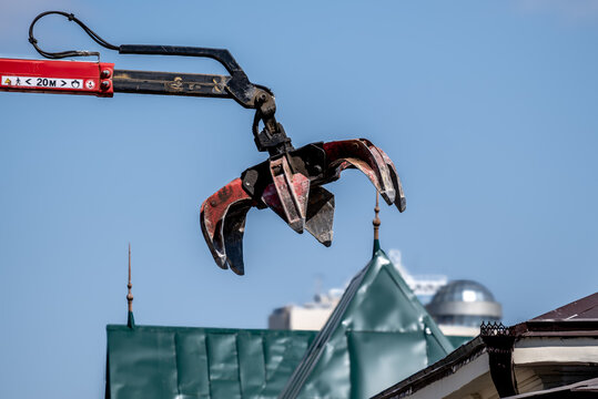 Excavator bucket with grippers in the air. - Powered by Adobe